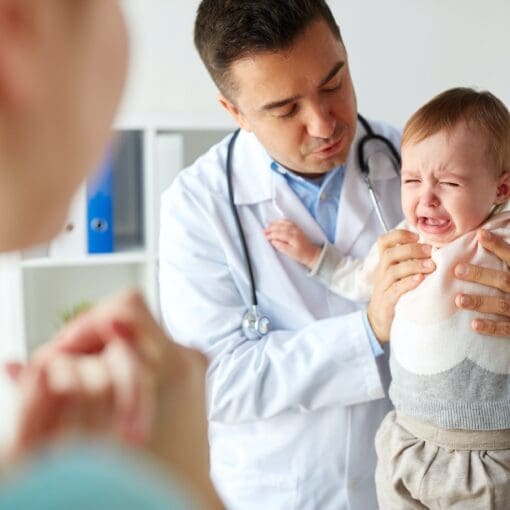 Doctor Or Pediatrician With Crying Baby At Clinic