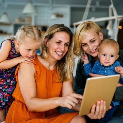 Happy Lesbian Couple With Little Adopted Girl At Home