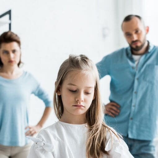 Selective Focus Of Upset Child Near Sad Parents Standing At Home