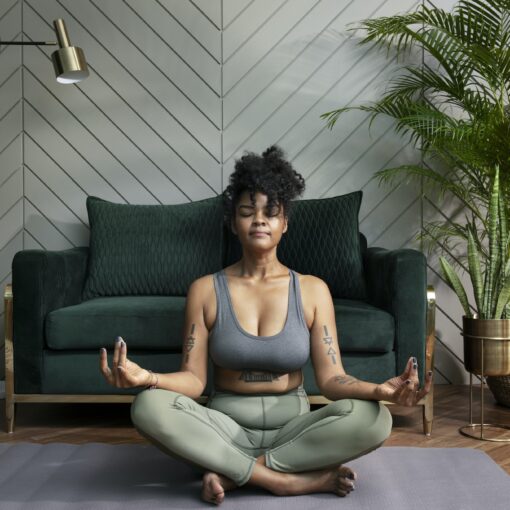 Healthy Woman Meditating In The Living Room