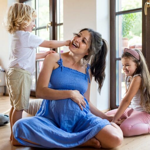 Pregnant Woman With Small Children Indoors At Home, Playing